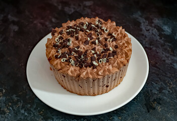 Norwich, Norfolk, UK – December 25 2020. An illustrative editorial photograph of a close up of a frozen double chocolate gateau on a white plate on a marbled black kitchen worktop