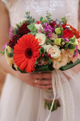the bride holds a bouquet of autumn flowers