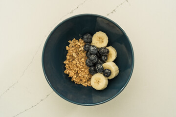 muesli bowl with sliced banana, blueberry, kiwi and strawberry on wooden table, closeup view. Healthy eating, healthy breakfast dieting concept