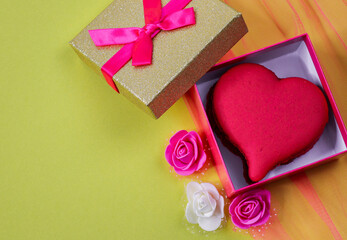 box with hearts and roses.
A heart-shaped dessert maccaron lies in an open box on the right against...