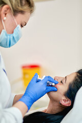 Close up of hands of cosmetologist making injection.