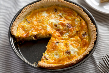 Homemade Bacon Quiche with Eggs and Cheddar Cheese, side view. Close-up.