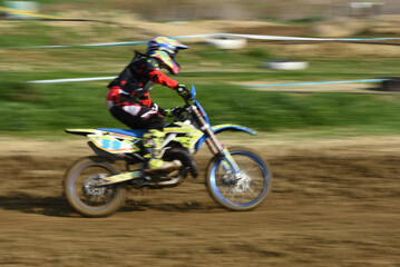 Obraz na płótnie Canvas Unrecognized athlete riding a sports motorbike on a motocross racing