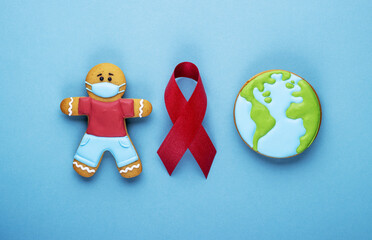 red ribbon and gingerbread boy and planet earth on blue background. world day of fight against cancer