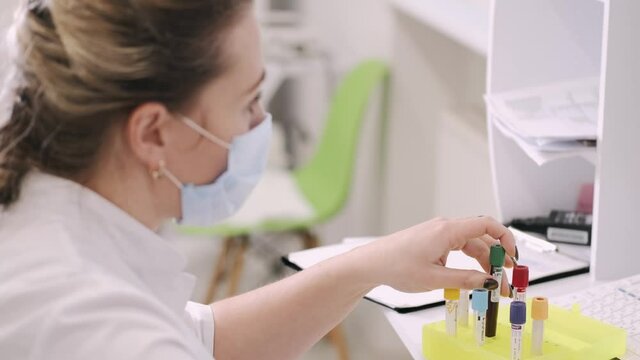 Female doctor adding test to database. Blood testing.