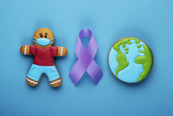purple ribbon and gingerbread boy and planet earth on blue background. world day of fight against cancer