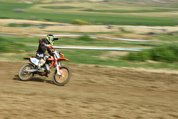 Obraz na płótnie Canvas Unrecognized athlete riding a sports motorbike on a motocross racing