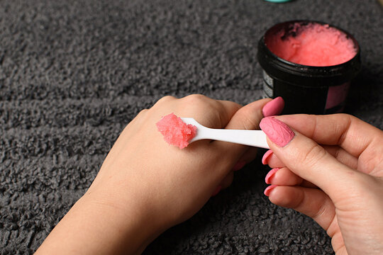 Female Hands Take A Pink Sugar Hand Scrub From A Black Jar. Spa At Home