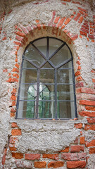 Window of an abandoned temple built of brick. Time destroyed the outer plaster. Time flow symbol