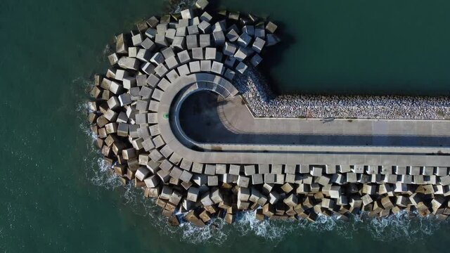 Aerial view of cement blocks protecting the shore from the waves in the port of Luanco in Asturias, Spain.
