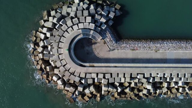Aerial view of cement blocks protecting the shore from the waves in the port of Luanco in Asturias, Spain.
