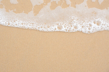 Fototapeta na wymiar Soft ocean wave on tropical sandy beach for background with copy space.