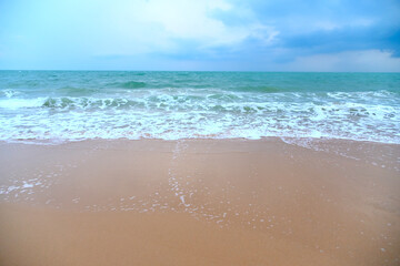 Fototapeta na wymiar Tropical beaches with sandy beach and ocean wave in the evening during the rainy season.