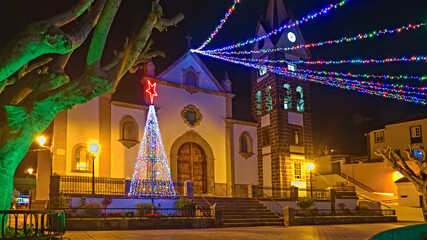 Obraz premium Christmas lights in a small town on the Canary Island of Tenerife, colorful, bright and with illuminated palm trees.