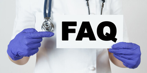 The doctor points his finger at a sign that says -FAQ. Frequently asked questions
