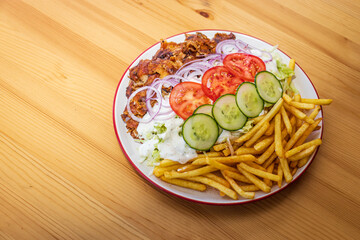 Doner kebab or gyros on a plate with french fries