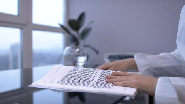 Female hands open document folder, reading the document, turning page