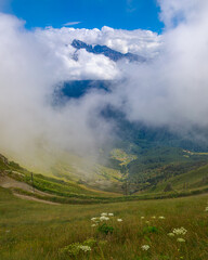 Landscape of the Caucasus mountains, clouds descend from the peaks.