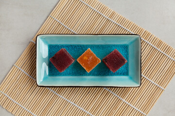 Fruit marmalade on rectangular serving plate, top view. Oriental or Asian sweets for tea made from fresh berries and natural juice