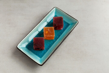 Fruit marmalade on rectangular serving plate. Oriental or Asian sweets for tea made from fresh berries and natural juice. Selective focus, copy space