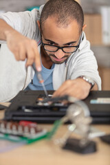 close-up of technician repairing laptop at desk