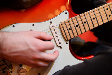 Musician playing with an electric guitar pick