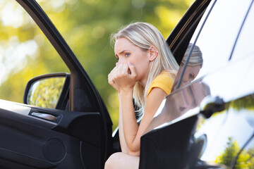 young woman is depressed in her car