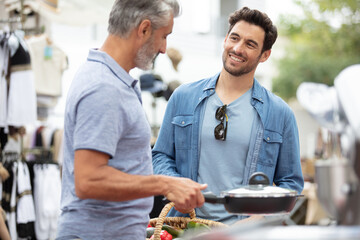 friendly men buying kitchen hardware at the market