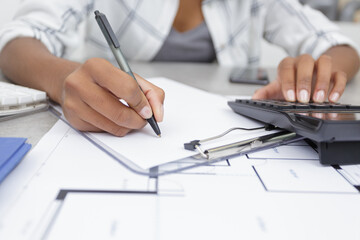 woman is writing a notes in a clipboard