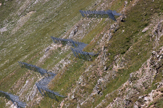 Metal avalanche protection structures on a mountain slope in the Alps, South Tyrol in Italy