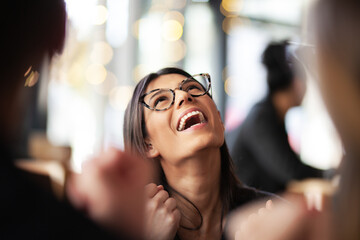 Lovely girl cheering success with coleagues and friends at a cafe. Looking up.
