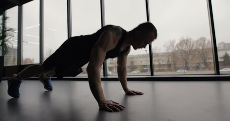 Man doing pushups exercise with hand claps in gym making his muscles more stronger