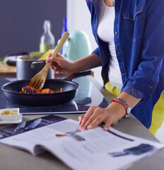 Obraz na płótnie Canvas Young woman in the kitchen preparing a food