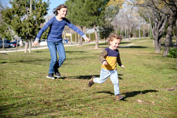 Two happy siblings having fun while running in springtime.