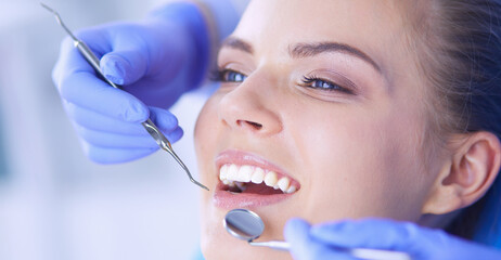 Naklejka premium Young Female patient with open mouth examining dental inspection at dentist office.