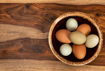Background With a Bowl of Colorful Eggs on a Wooden Cutting Board.tif