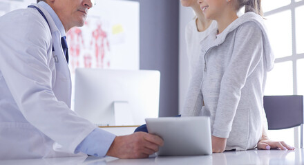 Portrait of a cute little girl and her doctor at hospital