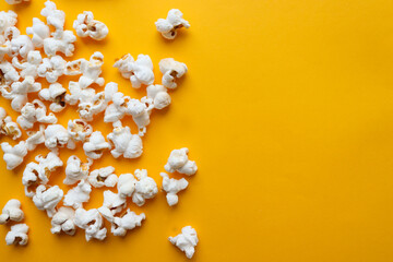 Popcorn on bright yellow background. Cinema, entertainment concept. Top view, flat lay, copy space