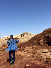 A male with a gun wading in the desert on the background of salt canyons of halite and gypsum in...