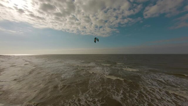 An aerial shot of a person kitesurfing in the Netherlands