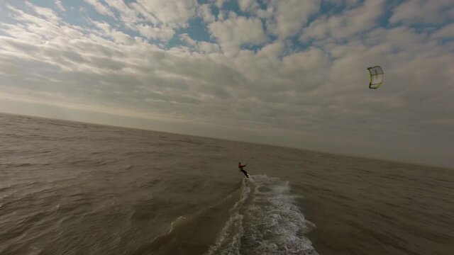 An aerial shot of a person kitesurfing in the Netherlands