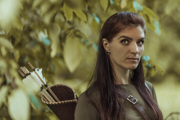 Portrait of a Woman with arrows in a quiver on a blurred background, close-up