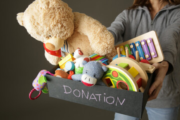 Volunteer women holding donation box with various children's toys