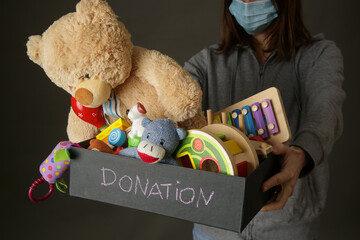 Volunteer women holding donation box with various children's toys
