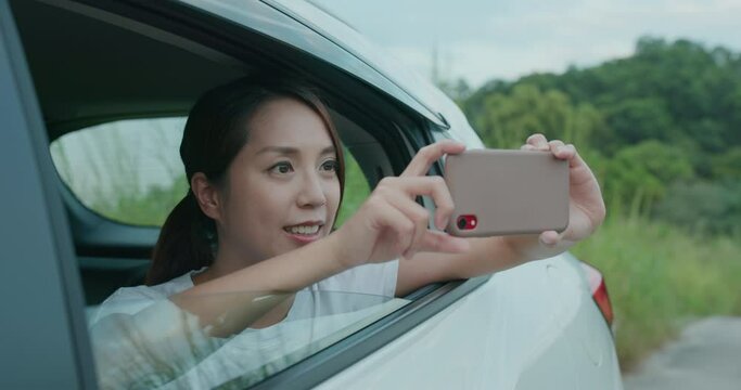 Travel woman use of smart phone to take photo with her car