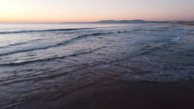 Low Flying Shot of Waves during Sunset at Costa da Caparica beach, Portugal