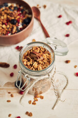 A vertical shot of delicious healthy vegan granola with pecan nuts in a fruity bowl with yogurt on...