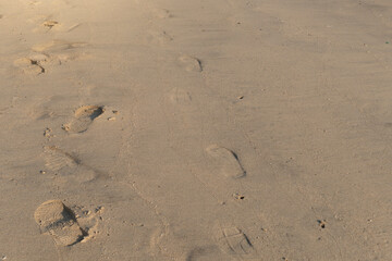 Footprints that pass on the sand on the beach.