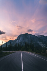 Fototapeta premium Road leading to mountains at sunset