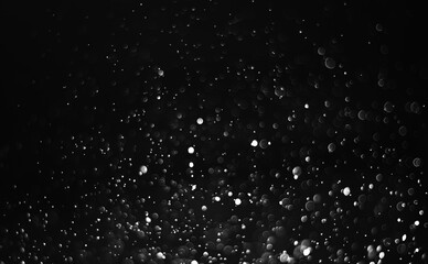 Glitter lights abstract background. Defocused bokeh on dark or black background.